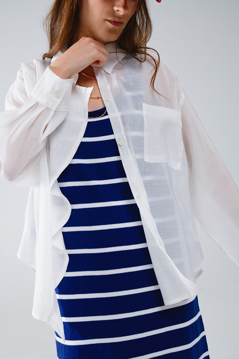 Blusa branca semi-transparente com pormenor de folhos na frente