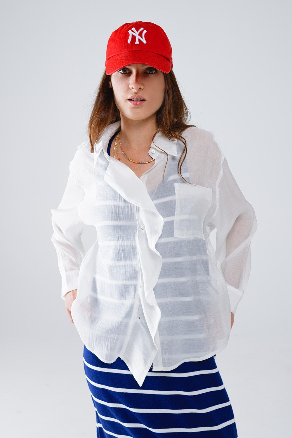 Blusa branca semi-transparente com pormenor de folhos na frente