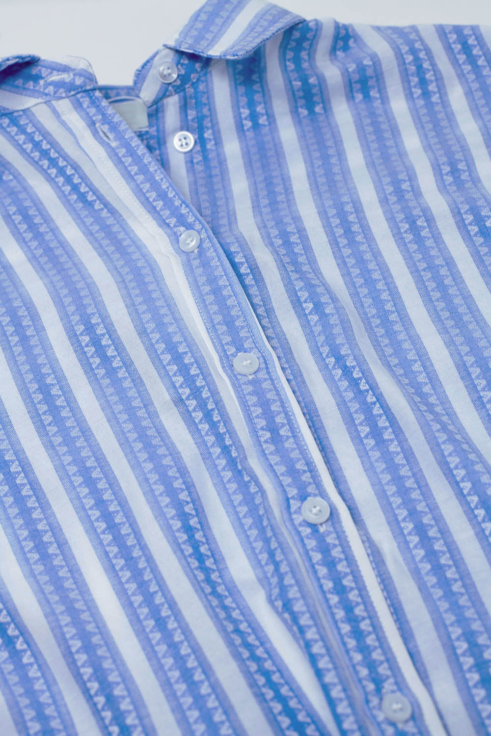 Blusa azul com riscas verticais e mangas curtas