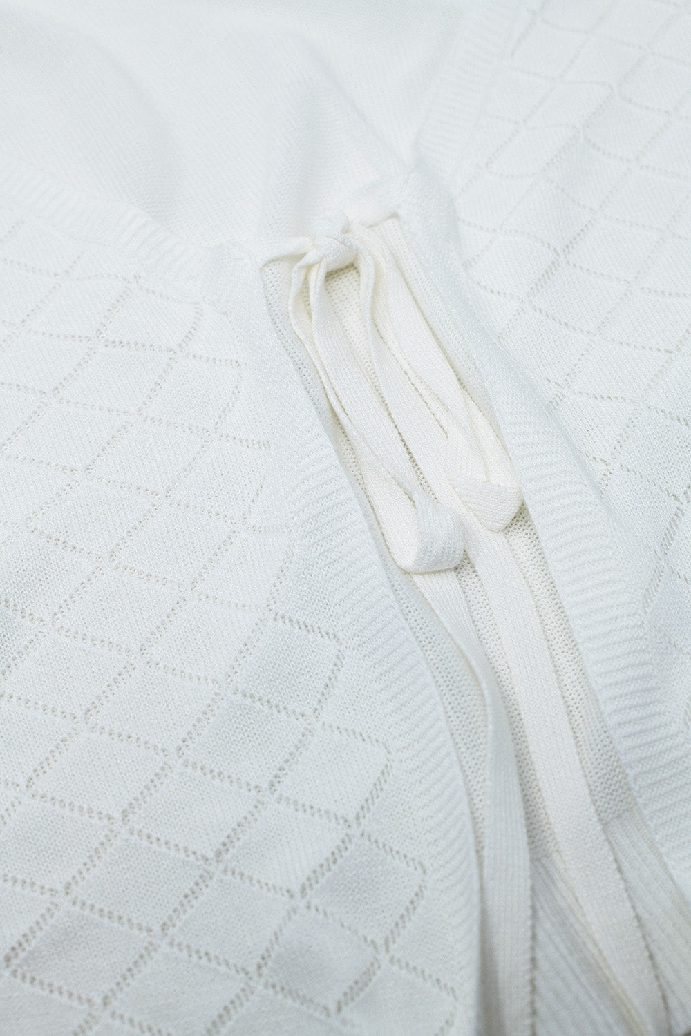 Casaco de malha branco com estampado Argyle e fecho com laço
