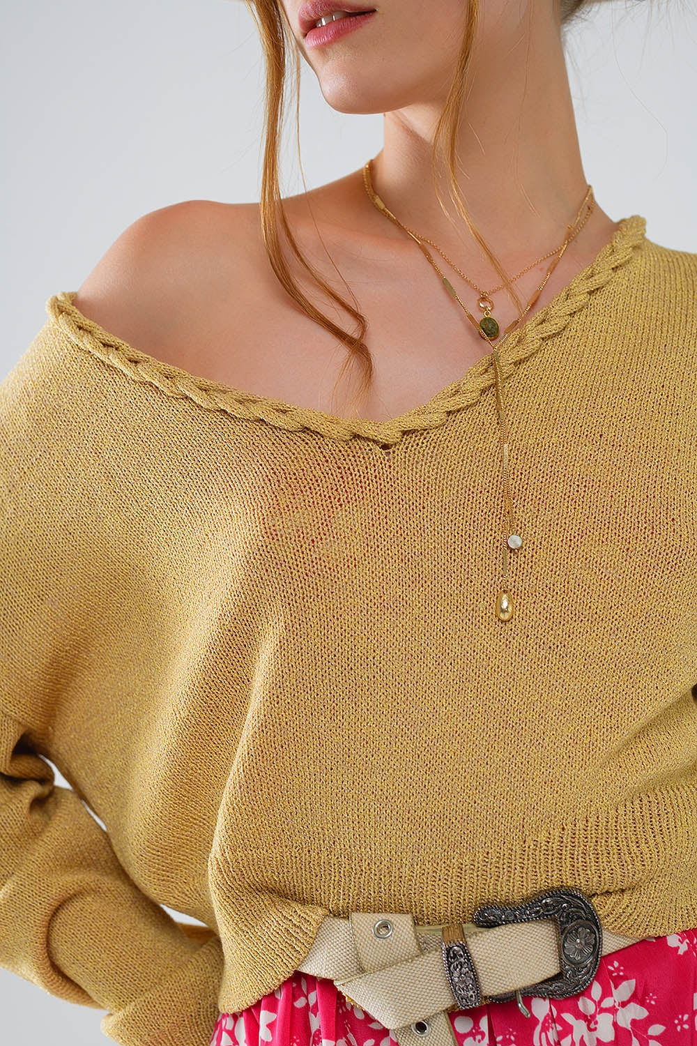 Camisola leve com decote em V largo e pormenores entrançados em dourado