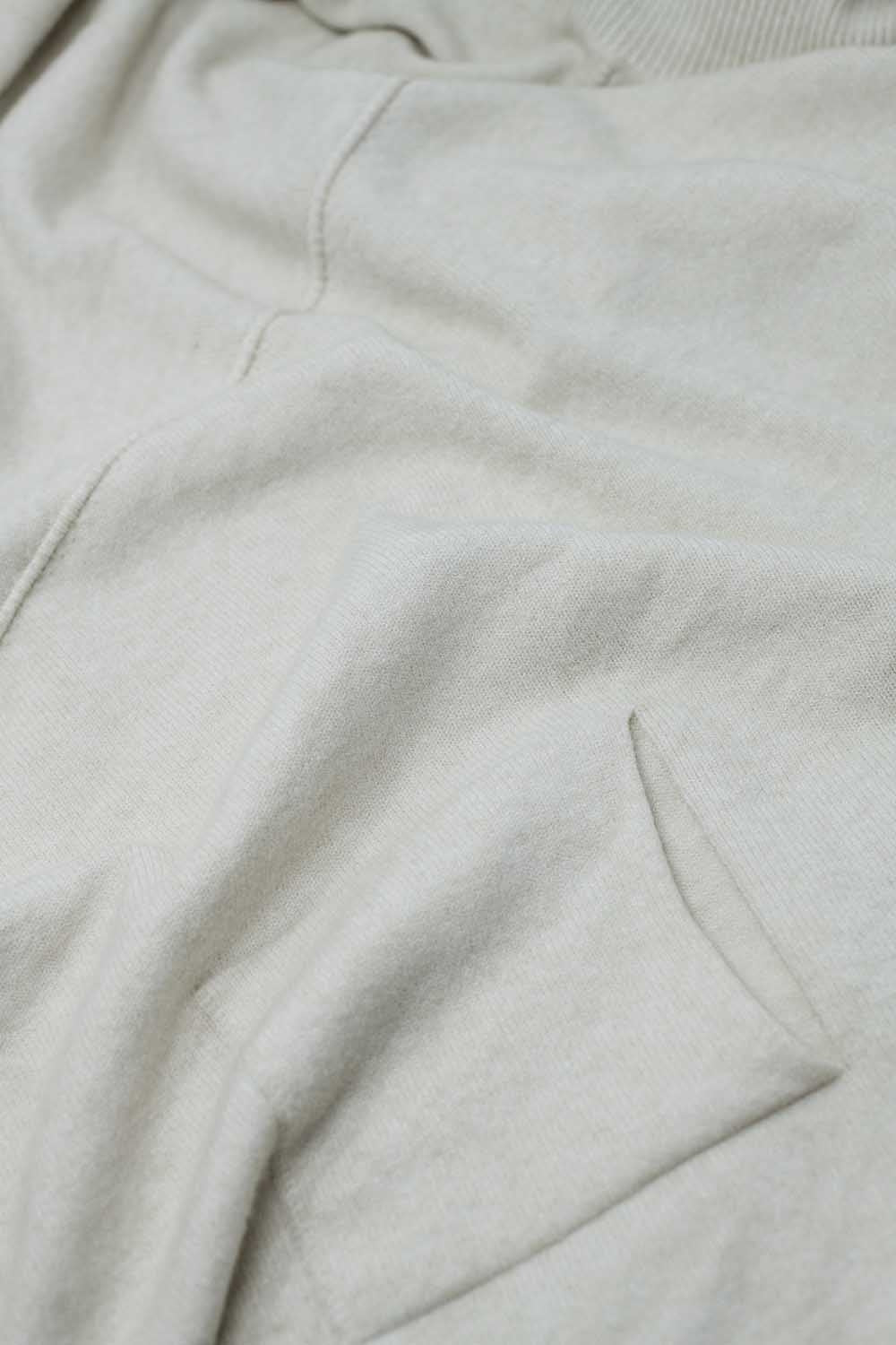 Camisola bege de grandes dimensões com bolsos à frente