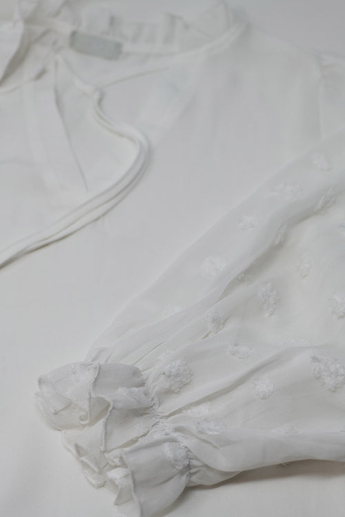 Blusa branca com pintas em manga comprida com decote em V