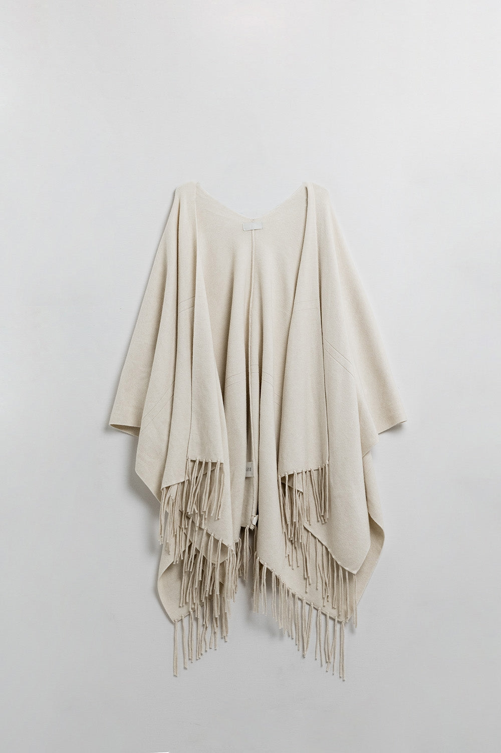 Poncho de malha macia em bege com franjas
